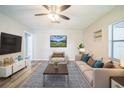 The living room is a relaxing area with a sofa, chair, a contemporary ceiling fan, and light wood floors at 507 Francis Blvd, Lakeland, FL 33801