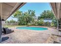 Backyard swimming pool with surrounding brick patio and lush tropical landscaping creating a private oasis at 51 Oakleigh Ln, Maitland, FL 32751