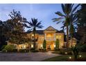 Elegant home with a manicured lawn, mature trees, and a circular driveway at 3499 Rockcliff Pl, Longwood, FL 32779