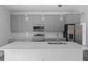 Modern kitchen featuring gray cabinets, quartz countertops, and stainless steel appliances at 16941 Sw 30Th Avenue Sw Rd, Ocala, FL 34473