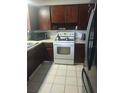 Cozy kitchen featuring wood cabinets, white appliances, and tile flooring at 108 5Th Jpv St, Winter Haven, FL 33880