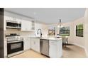 Modern kitchen featuring stainless steel appliances and white cabinetry at 7972 Snowberry Cir, Orlando, FL 32819
