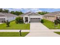 Exterior view of a single-Gathering home with a well-manicured lawn and two-car garage at 10204 Spring Lake Dr, Clermont, FL 34711