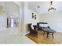 Living room with tiled floor, seating area, and view into the dining area at 13136 S Ashington Pointe Dr, Orlando, FL 32824