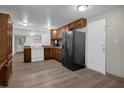 Modern kitchen with wood cabinets, white appliances, and vinyl flooring at 6937 Gibraltar Rd, Orlando, FL 32822