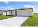 New construction home with a bright white exterior, two car garage and a concrete driveway at 1344 Oak Valley Dr, Auburndale, FL 33823