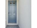 A modern front door with a grey finish, set against a bright white stucco exterior at 1344 Oak Valley Dr, Auburndale, FL 33823