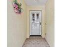 Close-up of the front door entrance, showing a white door with a decorative wreath on the textured wall at 1730 Stafford Springs Blvd, Mount Dora, FL 32757