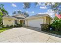 Inviting home exterior featuring a two-car garage, beautiful landscaping, and a charming facade at 1730 Stafford Springs Blvd, Mount Dora, FL 32757
