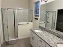 Spacious bathroom with a large walk-in shower, double vanity with granite countertop, and tile flooring at 16613 Point Rock Dr, Winter Garden, FL 34787