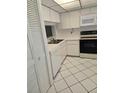 Galley kitchen with white cabinets and appliances at 11 Escondido Cir # 105, Altamonte Springs, FL 32701