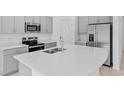 Bright kitchen with quartz countertops, stainless steel appliances, and ample cabinet space at 203 River Front Way, Edgewater, FL 32141