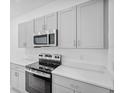 Modern kitchen with stainless steel appliances and gray cabinets at 203 River Front Way, Edgewater, FL 32141