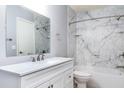 Bathroom featuring a modern vanity with sleek fixtures, mirror, bathtub and marble-style wall at 337 Goldstone Pl, Lake Mary, FL 32746