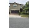 A charming two-story home with a two car garage sits on a neatly maintained lot with grass and shrubs at 8844 Corcovado Dr, Kissimmee, FL 34747