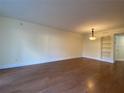 Empty living room with wood floor, yellow walls, ceiling light, and shelving near the doorway at 2432 Lemon Tree Ln # B, Orlando, FL 32839