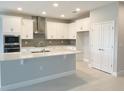 Modern kitchen with white cabinets, island, and stainless steel appliances at 2463 Francisco Art Ct, Oviedo, FL 32765