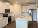 Modern kitchen with white cabinets, stainless steel appliances, and an island at 334 Rover Rd, Ormond Beach, FL 32174