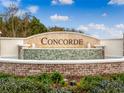 Well-manicured entrance sign for the 'Concorde' community surrounded by flowers and mature trees at 3491 Fort Mellon Ln, Sanford, FL 32773