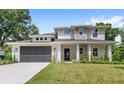 Well-maintained two-story home with stone pillars, modern garage door and lush green lawn at 634 Burch Ave, Winter Garden, FL 34787