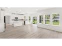 Bright, open-concept living room with modern white kitchen and large windows offering abundant natural light and scenic views at 634 Burch Ave, Winter Garden, FL 34787