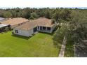 Aerial view of the property showcasing the lush green lawn and covered patio with tile roof at 11045 Belmere Isles Ct, Windermere, FL 34786