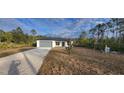 New construction home with driveway and surrounding trees at 1109 East Pkwy, Deland, FL 32724