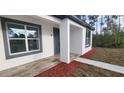 Front entrance with gray door and wood-look tile flooring at 1109 East Pkwy, Deland, FL 32724