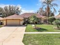 Tan house with a two-car garage and neatly landscaped lawn at 10324 Pleasant View Dr, Leesburg, FL 34788