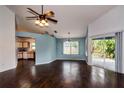 Open living area with sliding glass doors to patio, wood-look floors, and view into adjacent kitchen at 10557 Glassborough Dr, Orlando, FL 32825