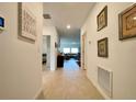Inviting hallway with tile flooring, decorative wall art, and views into the living area at 1393 Asher Mason Ave, Kissimmee, FL 34744