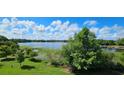 Expansive lake view with lush greenery and a picturesque sky, perfect for serene enjoyment at 593 Lake Wildmere Cv, Longwood, FL 32750