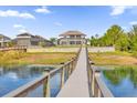 Spacious backyard featuring a view of the home from the dock on the water at 13016 Shady Retreat Loop, Clermont, FL 34711