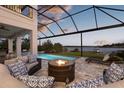 Inviting screened pool area with a cozy fire pit and comfortable seating, perfect for relaxation by the lake at 13016 Shady Retreat Loop, Clermont, FL 34711