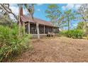 Charming cabin featuring a screened porch, surrounded by lush landscaping and mature trees at 2459 Adelia Blvd, Deltona, FL 32725