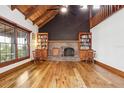 A cozy living room featuring a brick fireplace, built-in bookshelves, hardwood floors and natural light at 2459 Adelia Blvd, Deltona, FL 32725