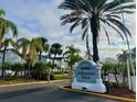 Millennium Palms Condominiums community entrance surrounded by lush palm trees and well maintained landscaping at 4743 S Texas Ave # 4743B, Orlando, FL 32839