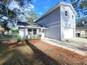 An eye-level shot of a light blue house with a white garage door, and partial landscape at 3505 Pine Ridge Ct, Orlando, FL 32808