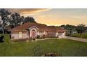 Single-story house with a landscaped yard, featuring a two-car garage at 5825 Princess Caroline Pl, Leesburg, FL 34748