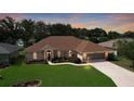 Charming single-story home featuring a well-manicured lawn and a screened two-car garage at dusk at 5825 Princess Caroline Pl, Leesburg, FL 34748