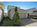 Attached garage with light beige exterior and a brick paver driveway at 5554 Stockade Blvd, Saint Cloud, FL 34771