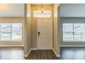 Bright foyer with hardwood floors, a decorative light fixture and natural light flooding in from the windows at 1928 Michigan Ct, Kissimmee, FL 34759