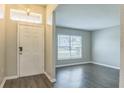 Inviting foyer with white door, transom window and hardwood floors leading to the living area at 1928 Michigan Ct, Kissimmee, FL 34759