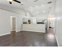 Open-concept living room showcasing wood floors, modern lighting, and seamless flow to kitchen at 1928 Michigan Ct, Kissimmee, FL 34759