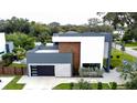 An aerial view of a contemporary home featuring a stylish garage, complemented by a well-maintained lawn and green landscape at 2522 Lafayette Ave, Winter Park, FL 32789