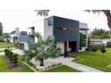 Modern home featuring a striking dark and white exterior, surrounded by vibrant landscaping and green lawns at 2522 Lafayette Ave, Winter Park, FL 32789