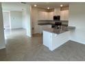 Open kitchen with island, granite countertops, and white cabinets at 3503 Fort Mellon Ln, Sanford, FL 32773