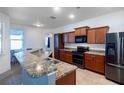 Modern kitchen with stainless steel appliances, beautiful granite countertops, and wooden cabinets at 176 Blackstone Creek Rd, Groveland, FL 34736