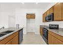 Bright kitchen featuring granite countertops, stainless steel appliances, and wood cabinets at 2812 Gabion St, Bartow, FL 33830