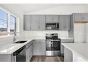 A modern kitchen featuring sleek gray cabinetry, stainless steel appliances, and ample countertop space at 3427 Narrows Dr, Lakeland, FL 33810